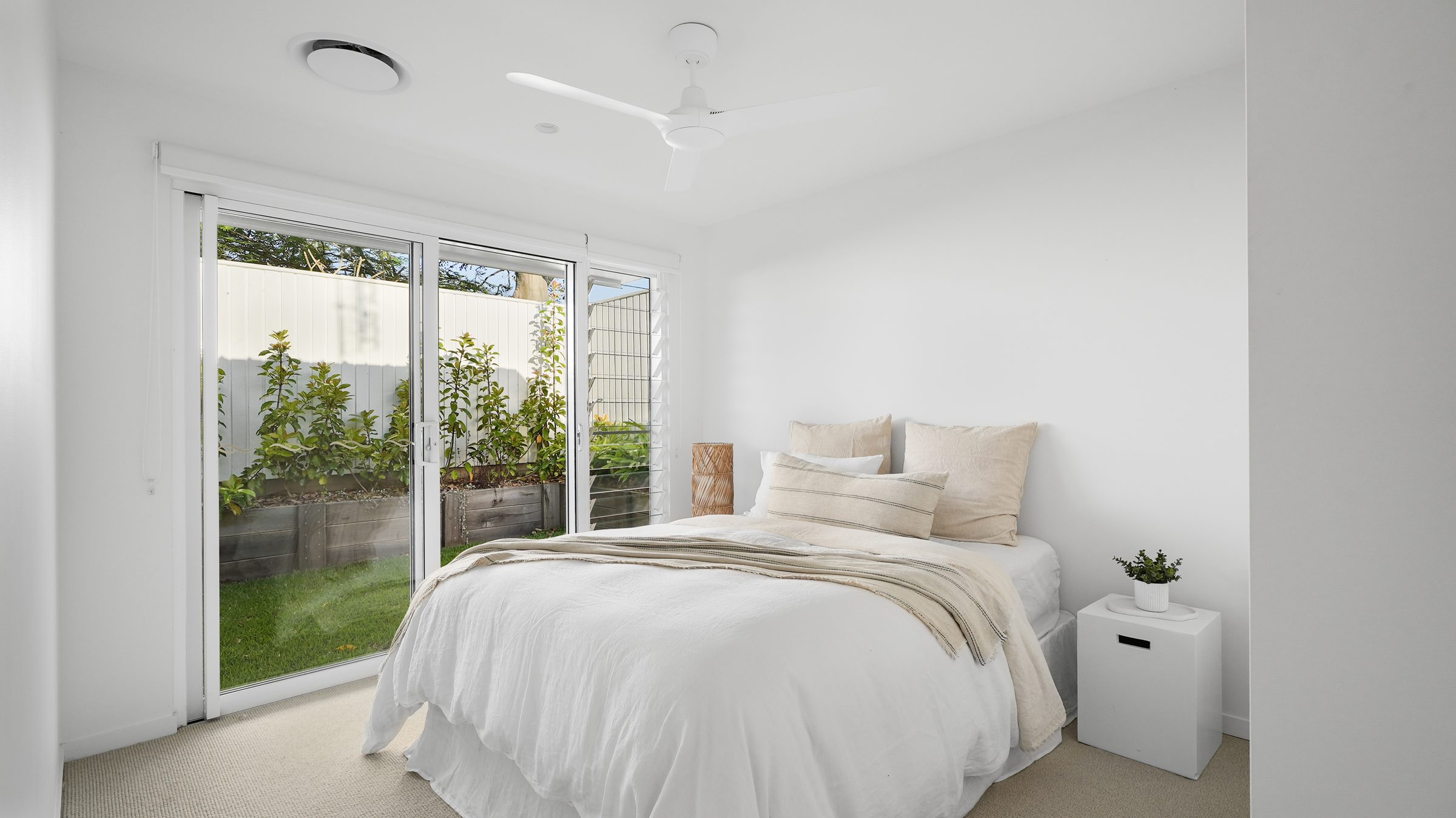 Guest bedroom with white linen and garden view